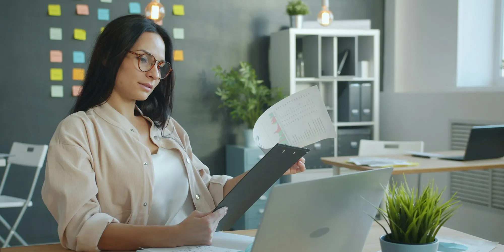 Business owner reviewing documents at her office desk