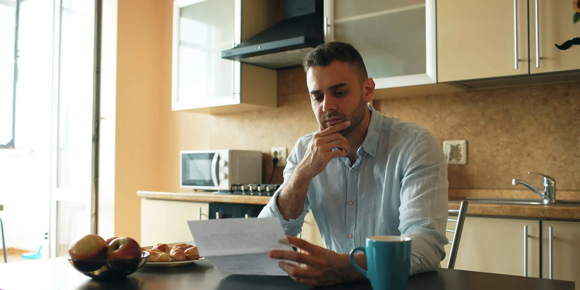 Business owner at his kitchen table reading a merchant cash advance contract