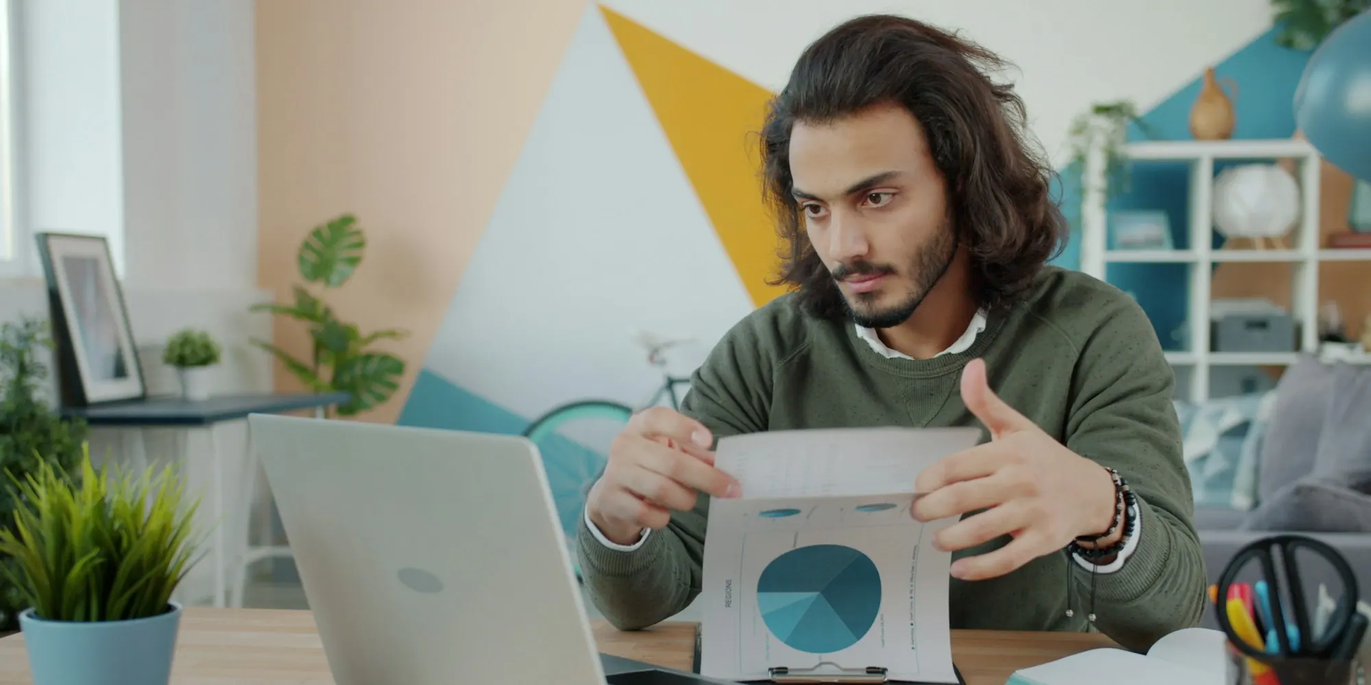 Small business owner at a laptop reviewing a printed funding offer