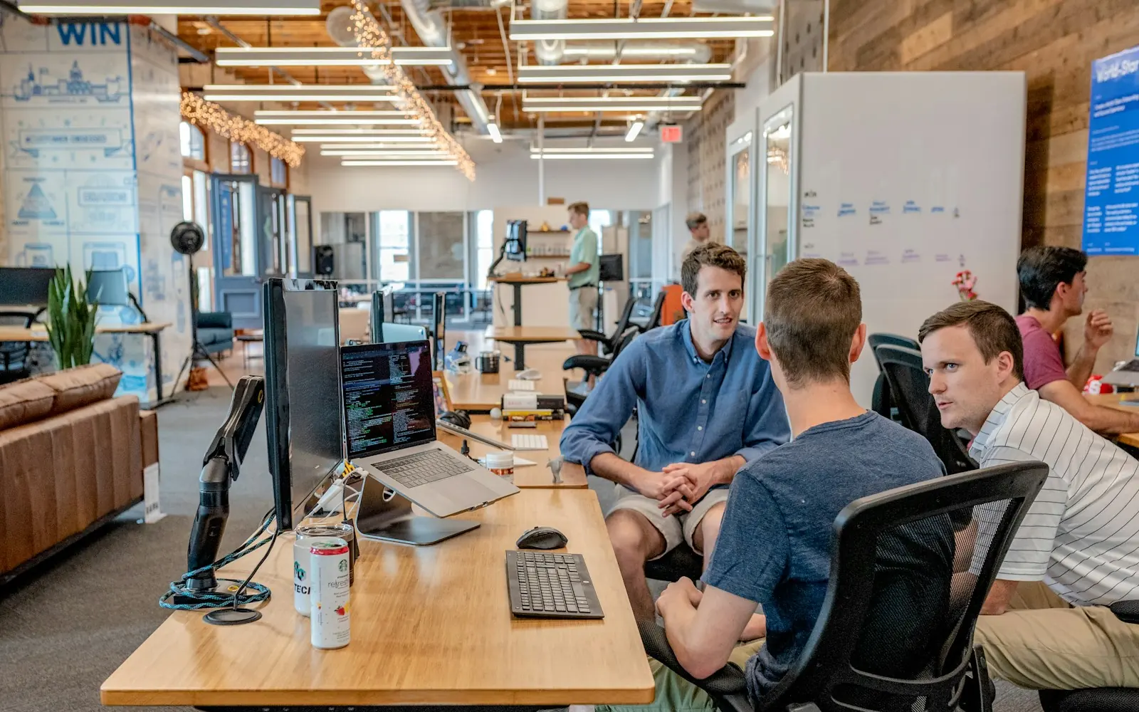 Three colleagues meeting at a table in an open office