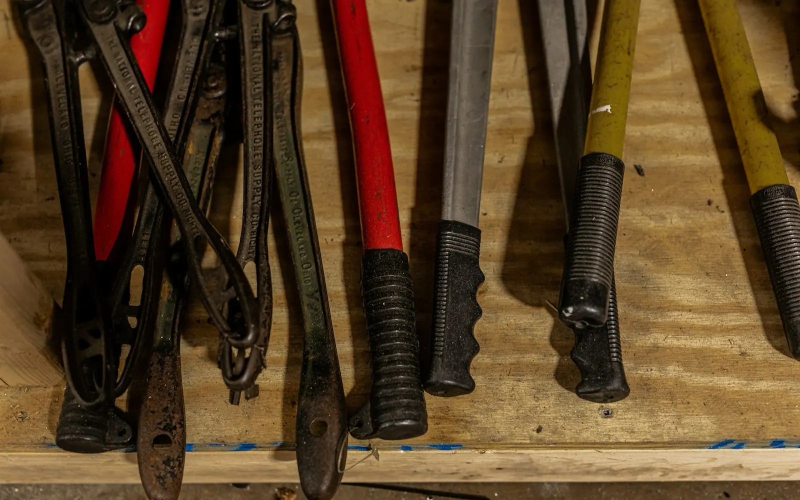 Rows of hand tools with black and red handles in a repair shop