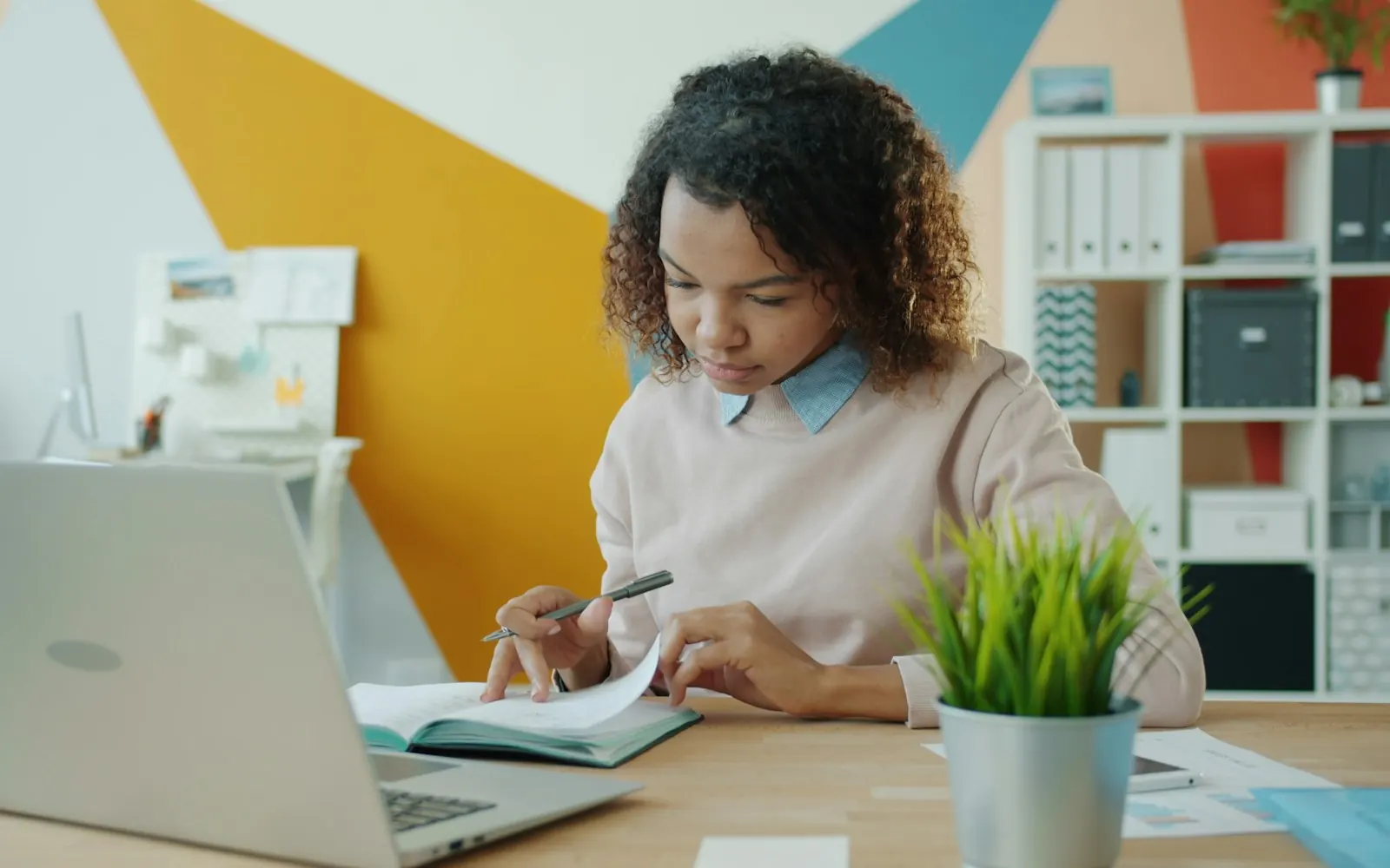 Business owner working at her desk with a laptop and an open notebook