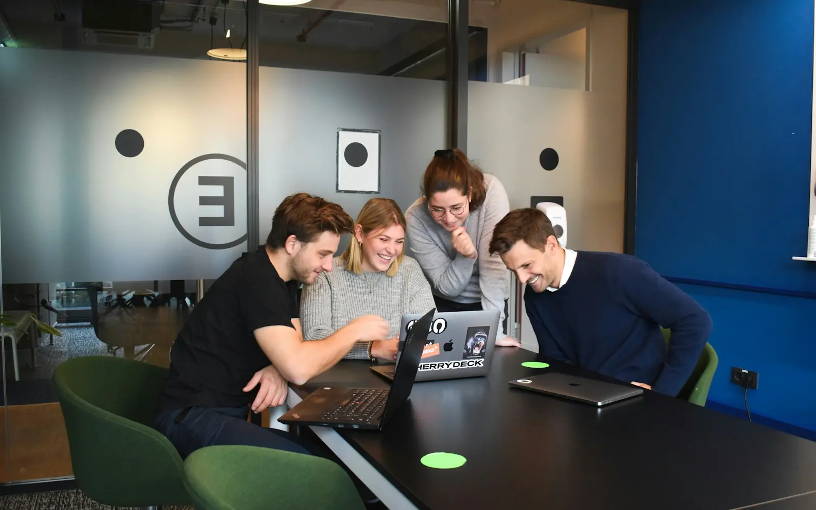 Small team working on laptops around a table