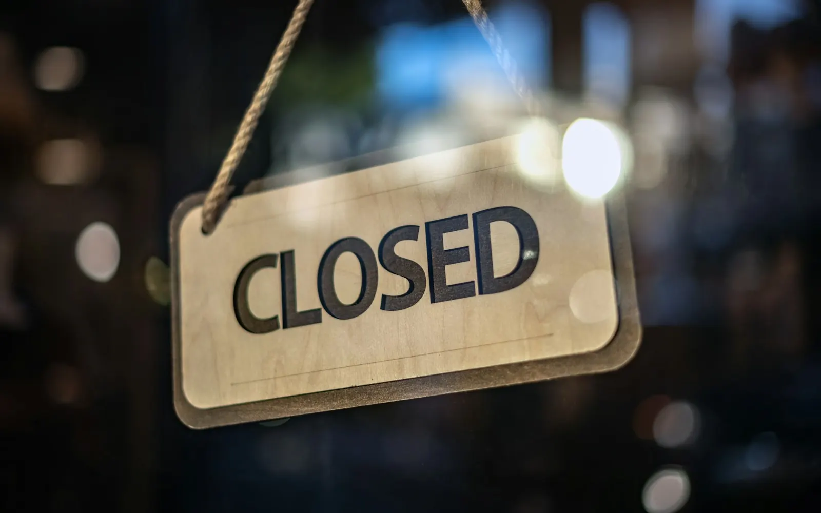 Closed sign hanging inside the glass door of a small business
