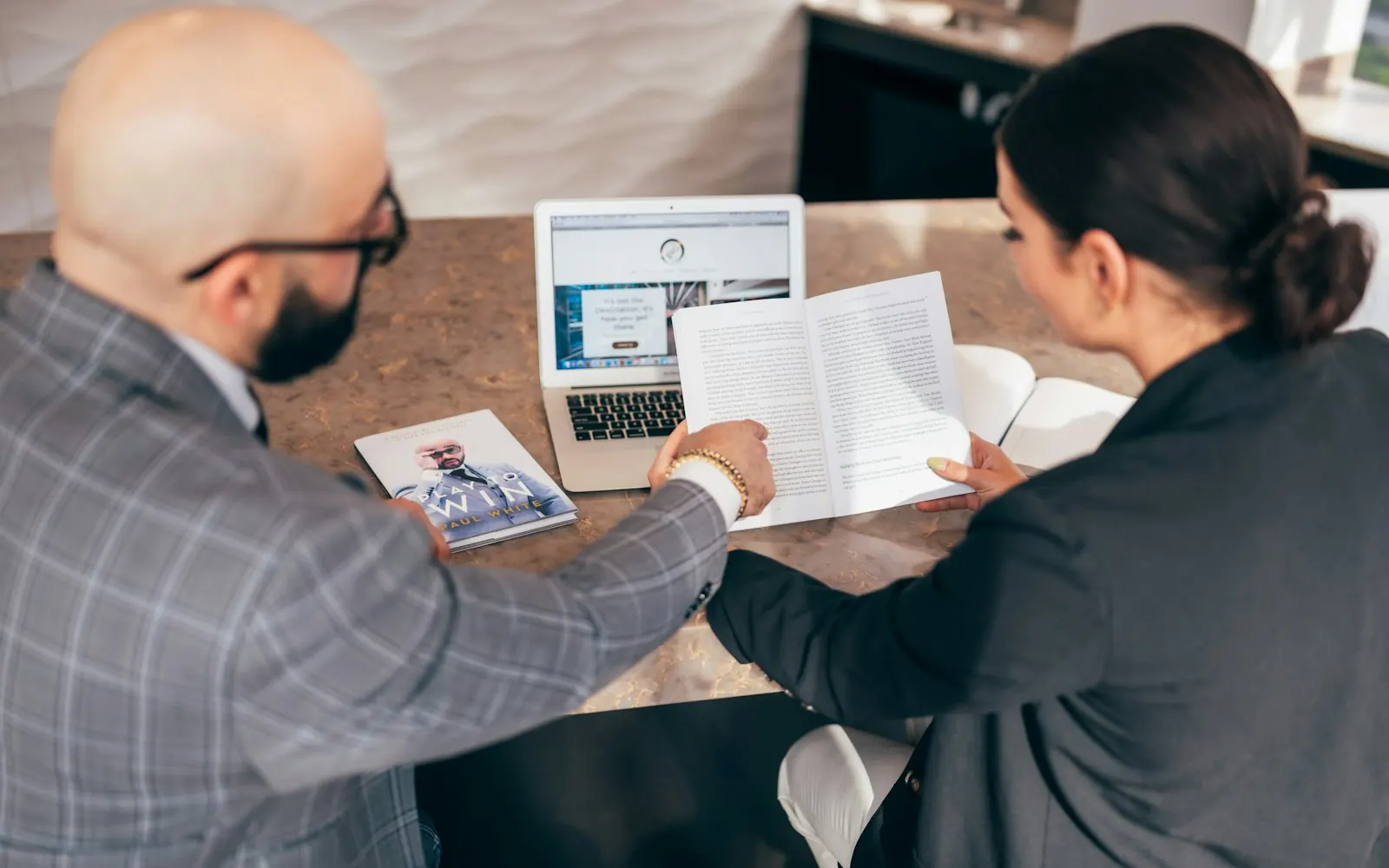 Business advisor going through paperwork with a client at a table
