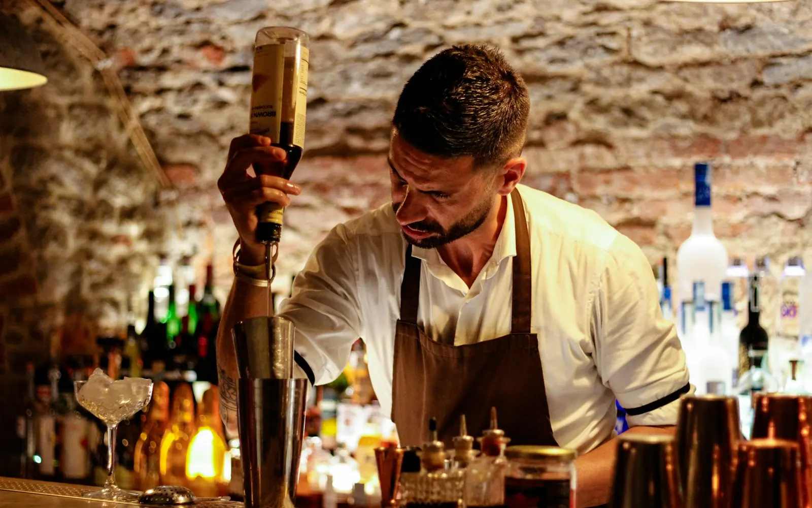 Bartender mixing a drink behind a hotel bar