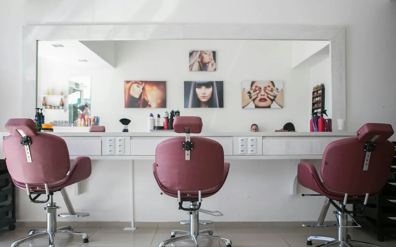 Salon chairs lined up at a white vanity
