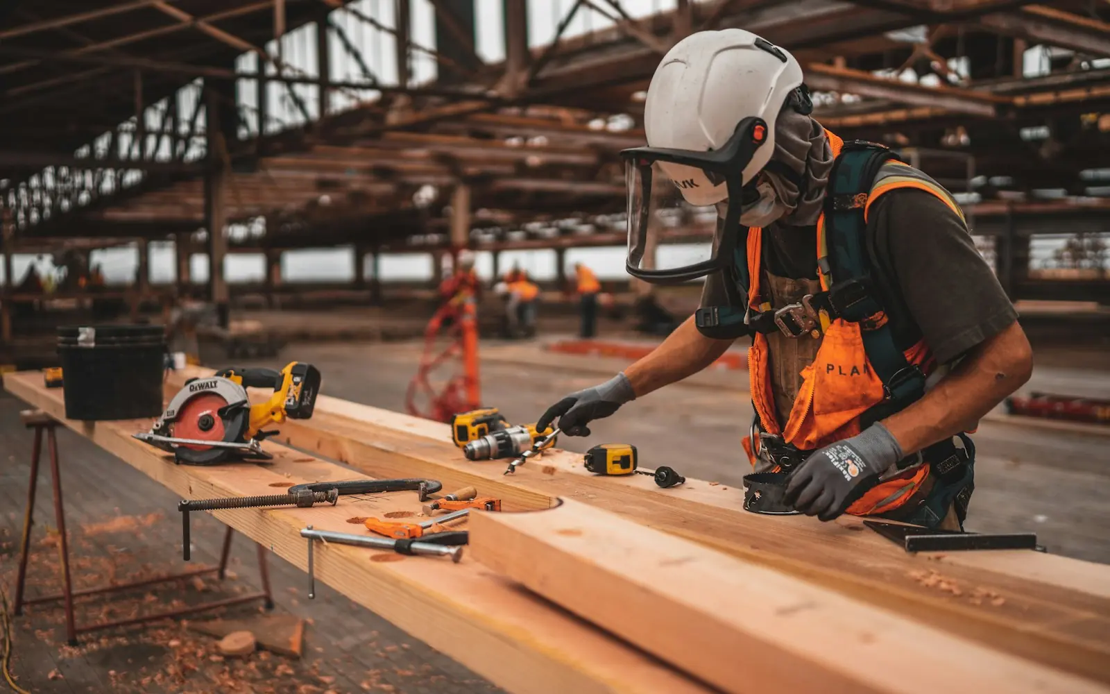 Construction worker in a hard hat and safety vest working at a bench